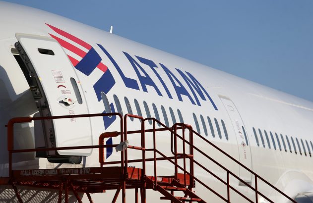 Avião LATAM com porta aberta e escada de embarque.