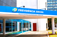 Entrada do prédio da Previdência Social com letreiro azul e o nome da instituição.