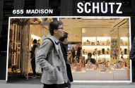 Pessoas passam em frente à loja Schutz (655 Madison) com sapatos expostos na vitrine.