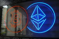 Letreiros neon: Bitcoin laranja refletido e Ethereum azul lado a lado.