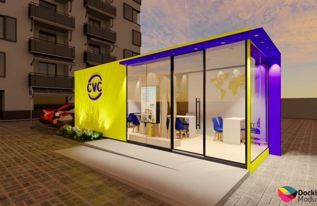 Quiosque modular CVC amarelo e roxo com janelas de vidro, em área externa pavimentada com edifício e carro.