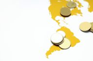 Moedas douradas genéricas sobre um mapa amarelo das Américas.