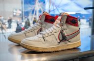 Um par de tênis Air Jordan 1 Off-White branco e vermelho em exposição.