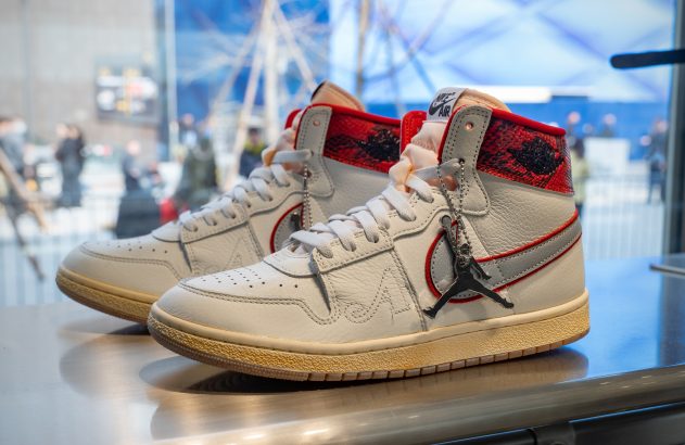 Um par de tênis Air Jordan 1 Off-White branco e vermelho em exposição.