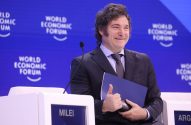 Javier Milei sorrindo e fazendo joinha em pódio do Fórum Econômico Mundial.