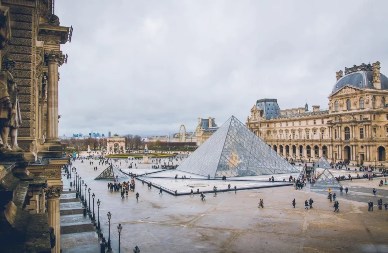 Turistas caminham em frente ao Museu do Louvre em Paris