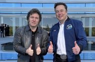 Elon Musk e Javier Milei sorrindo e fazendo sinal de positivo em frente a um prédio moderno.