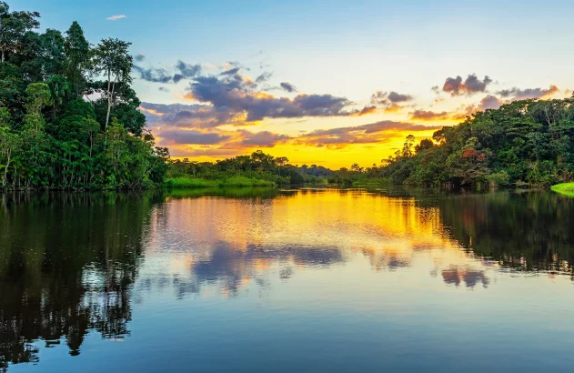Reflexo de um pôr do sol em uma lagoa dentro da Bacia da Floresta Amazônica. A bacia do rio Amazonas compreende os países Brasil, Bolívia, Colômbia, Equador, Guiana, Suriname, Peru e Venezuela.