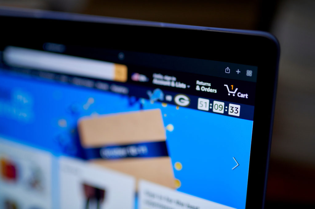 Tela de laptop exibindo site da Amazon com 1 item no carrinho e um timer de 51:09:33.