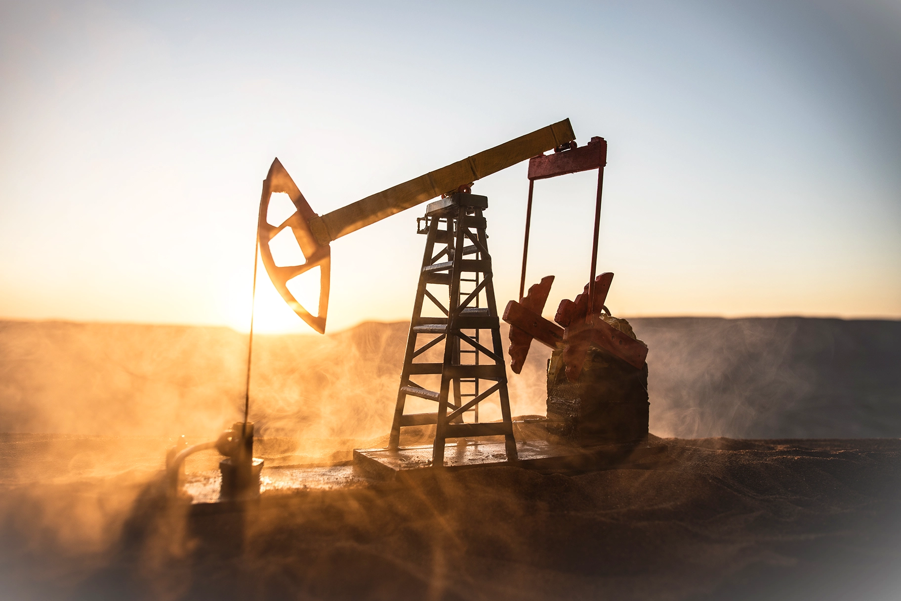 Bomba de óleo e fábrica de refino de petróleo ao pôr do sol