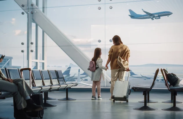 Área de embarque de aeroporto; mãe e filha observam avião decolando; embarque; viagem; turismo; avião
