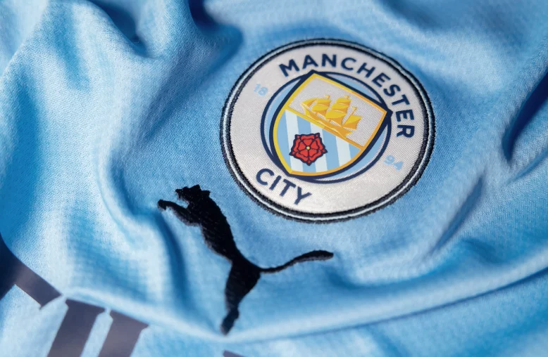 Detalhe do emblema do Manchester City em camiseta oficial do tiime