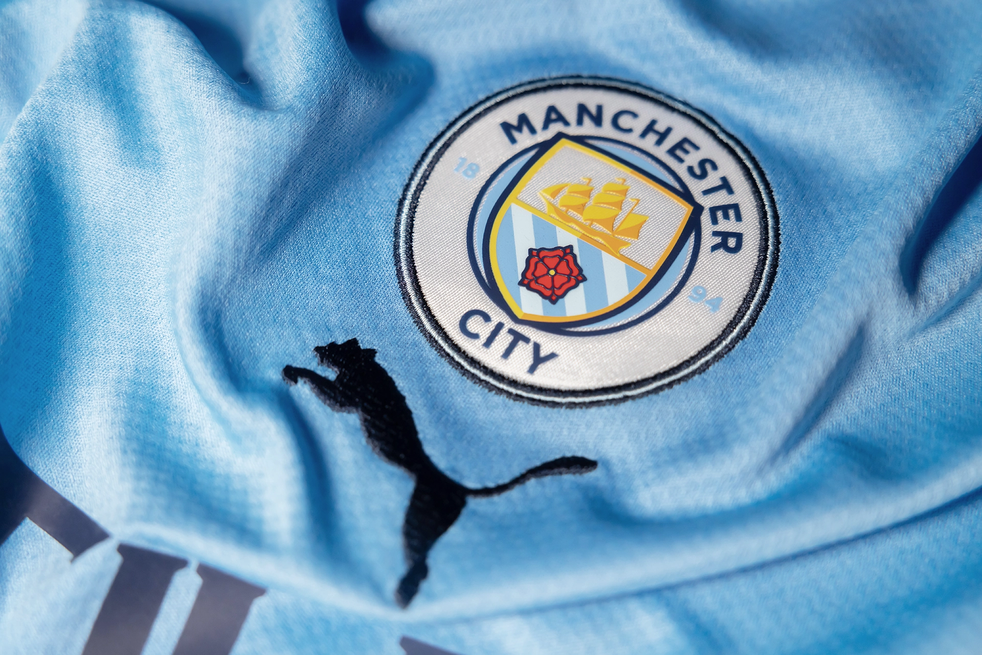 Detalhe do emblema do Manchester City em camiseta oficial do tiime