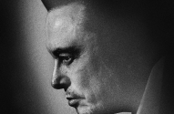 Homem em perfil, cabeça baixa, em preto e branco. Luz e sombra marcantes no rosto.
