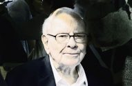 Retrato de Warren Buffett sorrindo e usando óculos.