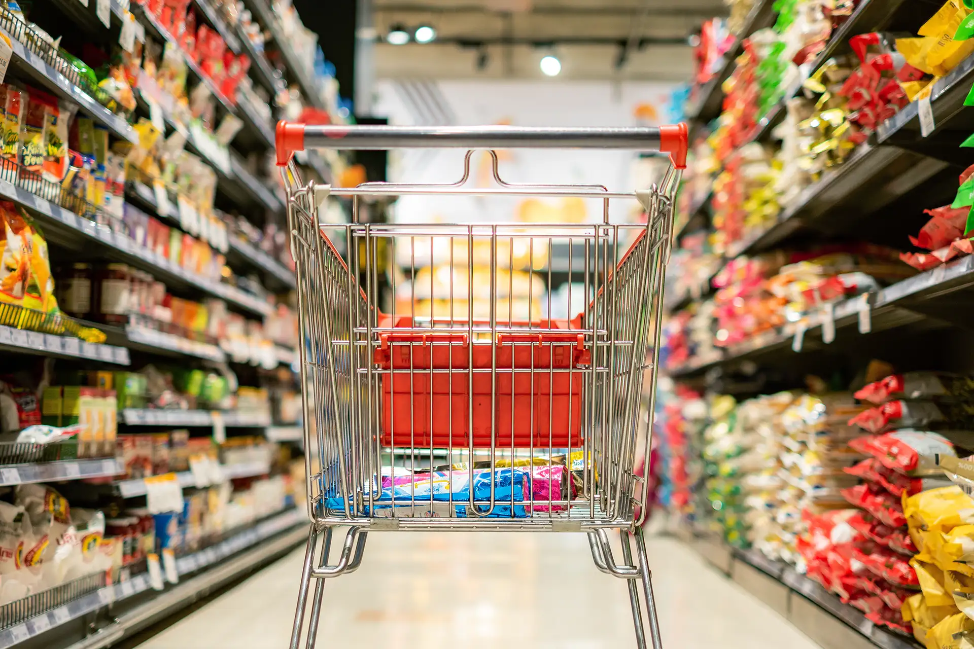 Carrinho no meio de um corredor de supermercado; varejo; alimentos; inflação