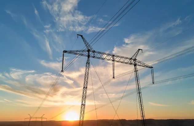 Silhueta escura da torre de alta tensão com linhas de energia elétrica ao nascer do sol. Conceito de transmissão de energia elétrica