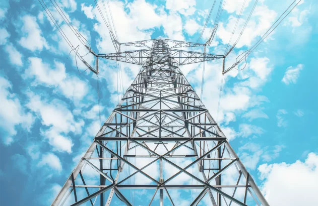 Torre de energia de aço com cabos de alta tensão contra o céu azul; eletricidade; energia elétrica