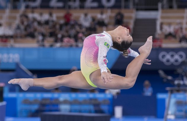 Ginasta brasileira salta em espacate no ar.