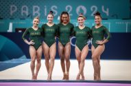 Cinco ginastas brasileiras em leotardos verdes "BRASIL", sorrindo e posando. Fundo: Paris 2024.