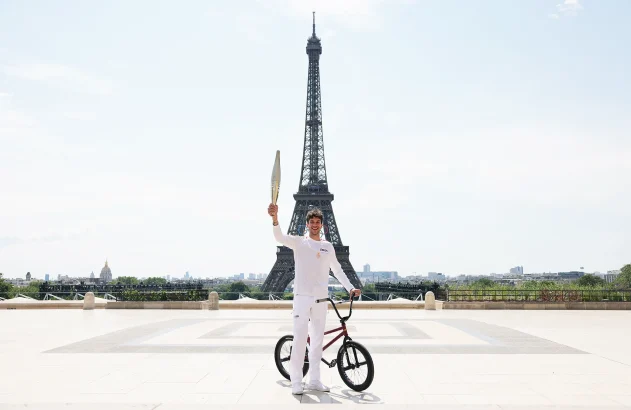 O portador da tocha Matthias Dandois, ciclista francês, posa para uma foto com a Tocha Olímpica na Place du Trocadero com a Torre Eiffel à vista durante o segundo dia do Revezamento da Tocha Olímpica de Paris 2024 em 15 de julho de 2024 em Paris, França. (Foto: Maja Hitij/Getty Images)