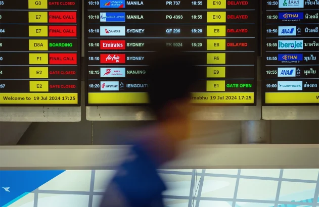 Um passageiro passa pelo quadro de embarque que mostra voos atrasados ​​no Aeroporto Suvarnabhumi por conta de uma interrupção global de TI causada por falhas nos sistemas da Microsoft e da Crowdstrike, afetando os usuários em 19 de julho de 2024 em Bangkok, Tailândia. (Foto: Mailee Osten-Tan/Getty Images); apagão global; TI; sistemas