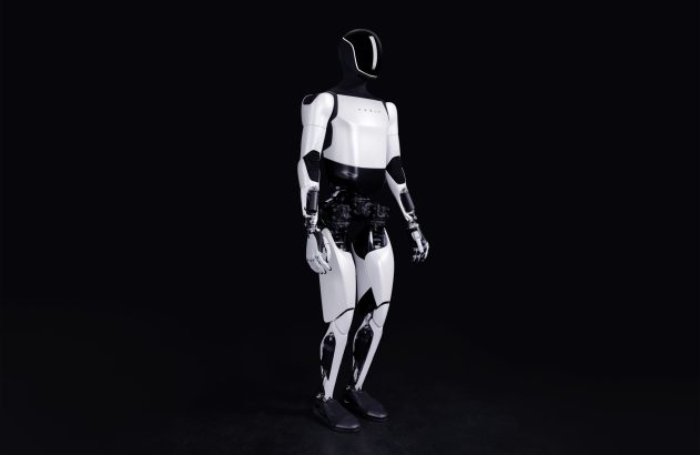 Robô humanoide branco e preto em pé contra fundo escuro.
