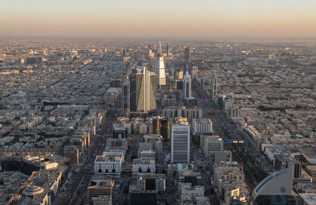 Vista aérea de uma cidade com arranha-céus e uma longa avenida.