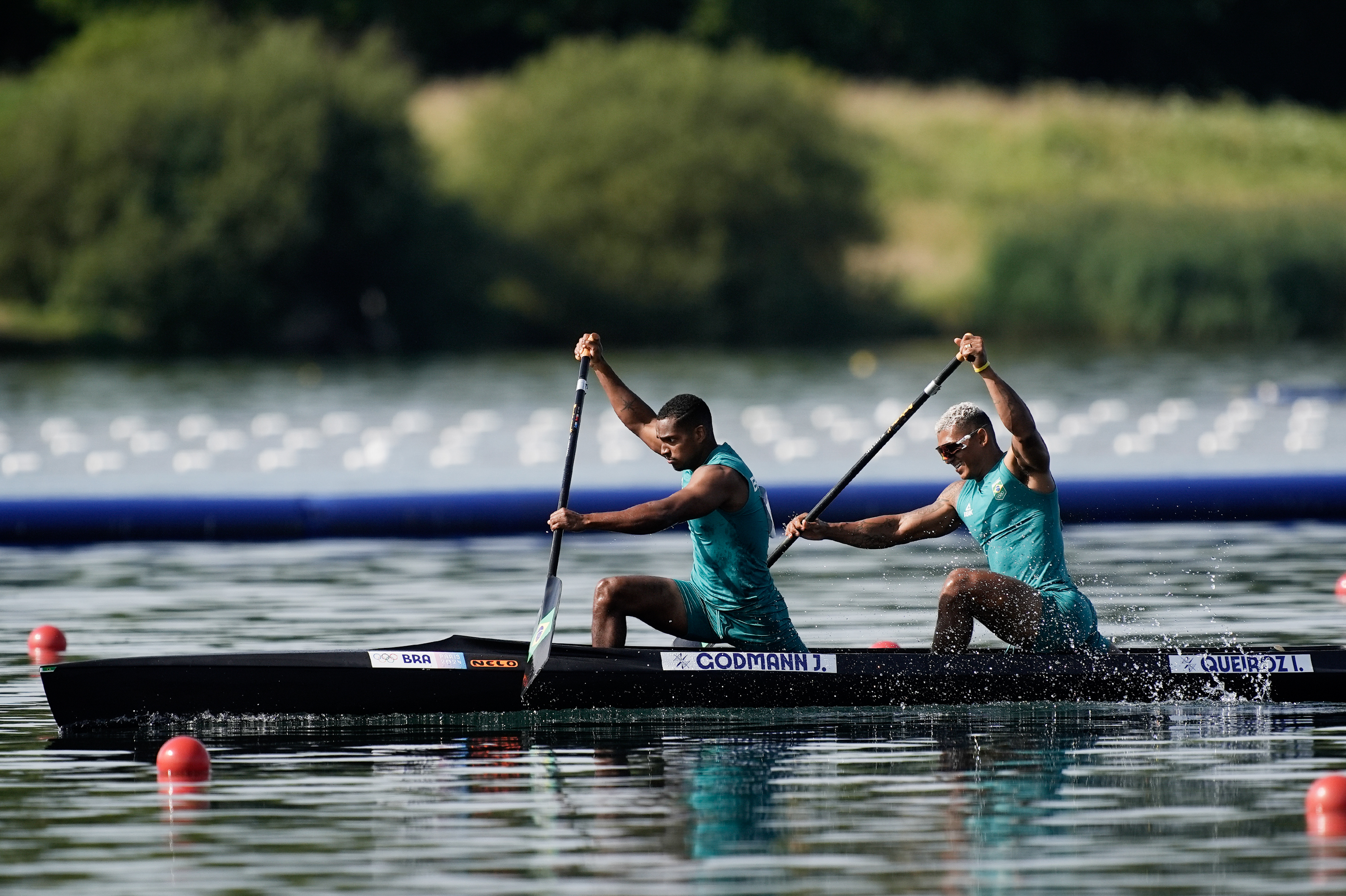 Atletas brasileiros Isaquias Queiroz e Jacky Godmann remam forte em canoa no lago.