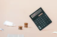 Calculadora, moedas e recibos de papel