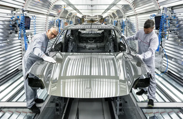Trabalhadores montam o novo Porsche Macan totalmente elétrico na fábrica de montagem da Porsche em 6 de maio de 2024 em Leipzig, Alemanha. O Macan elétrico é o segundo carro elétrico da Porsche depois do Taycan. A empresa também oferece dois carros híbridos. (Foto: Jens Schlueter/Getty Images)