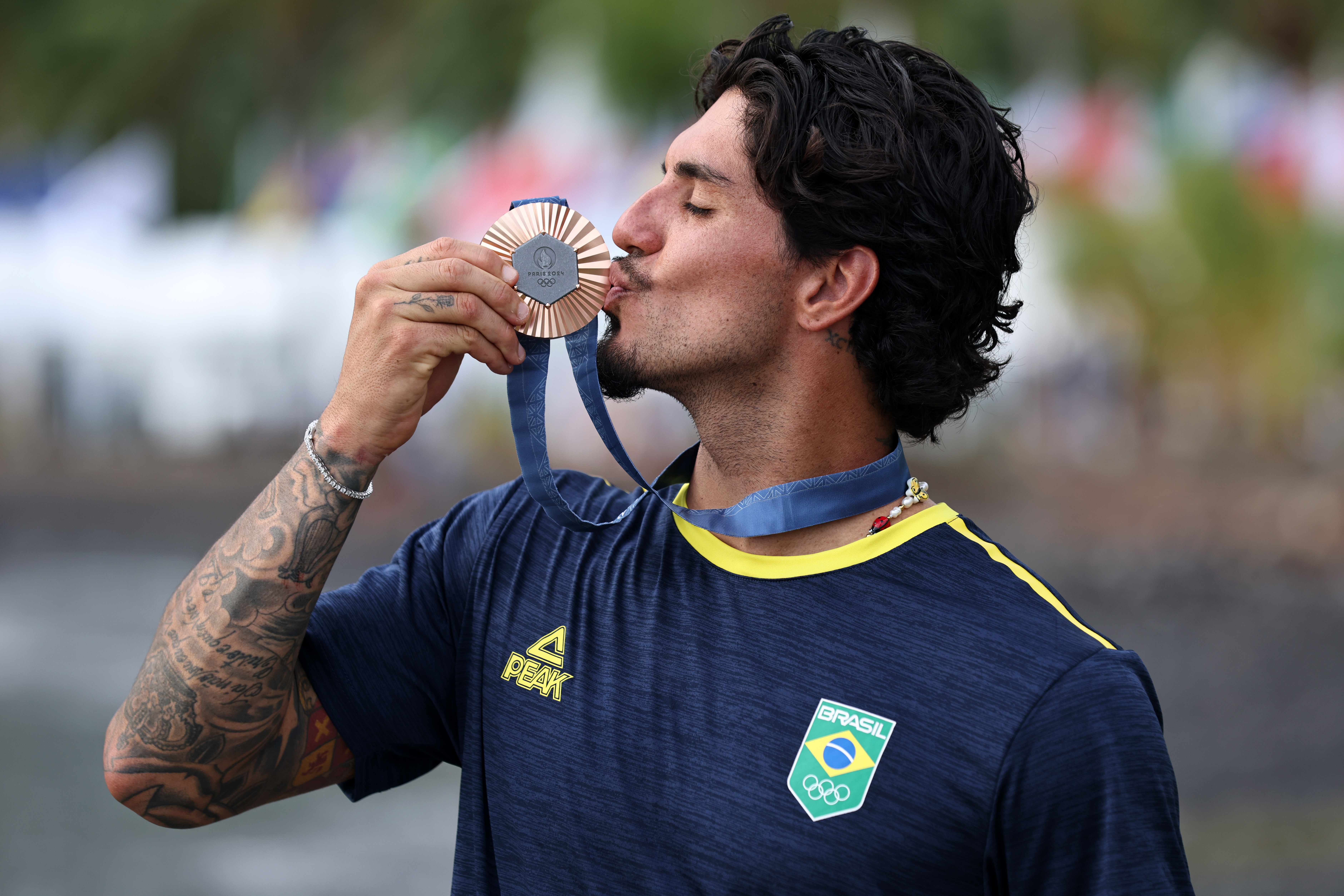 Atleta brasileiro beijando sua medalha de bronze olímpica.