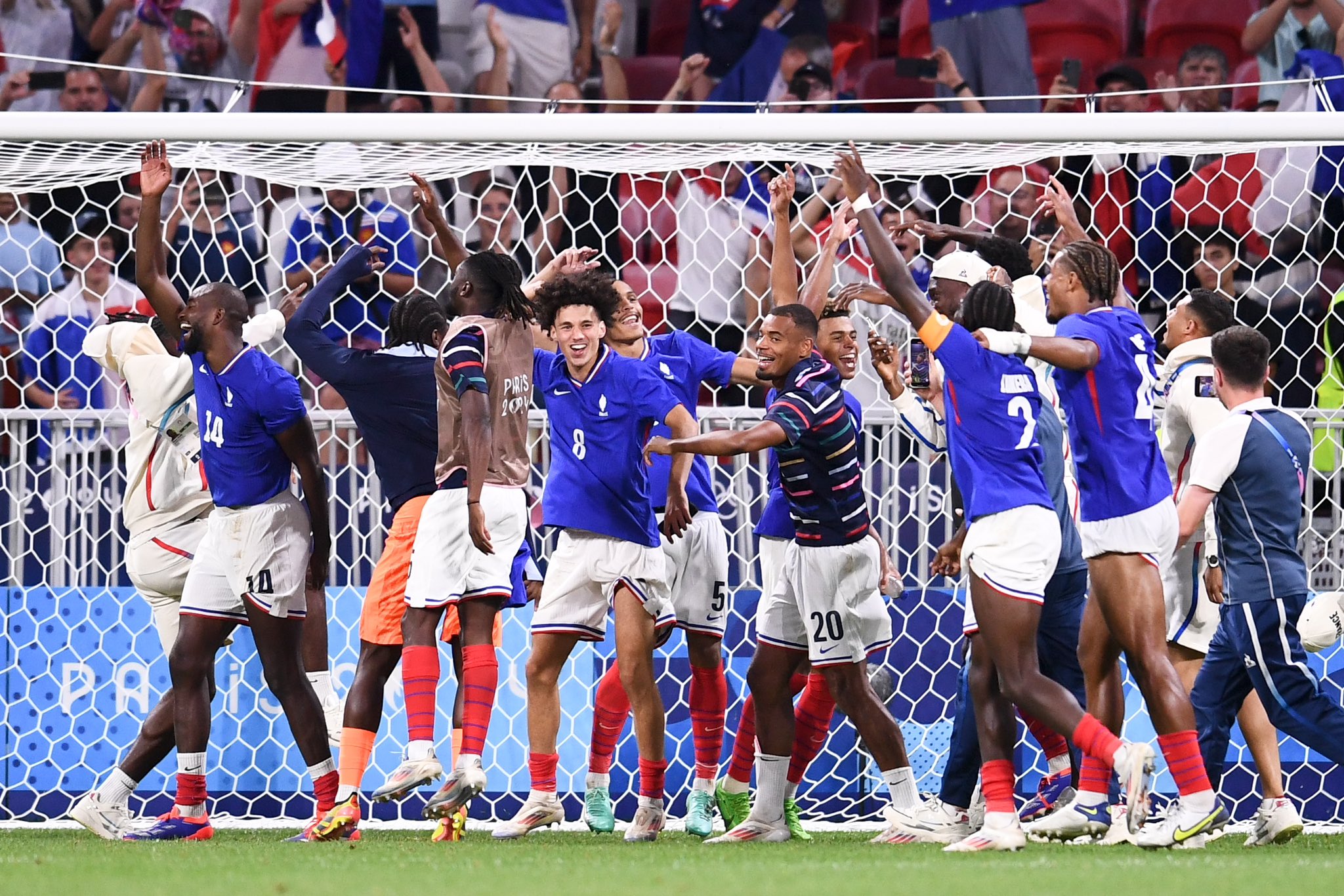 Jogadores da França celebram perto do gol em estádio.