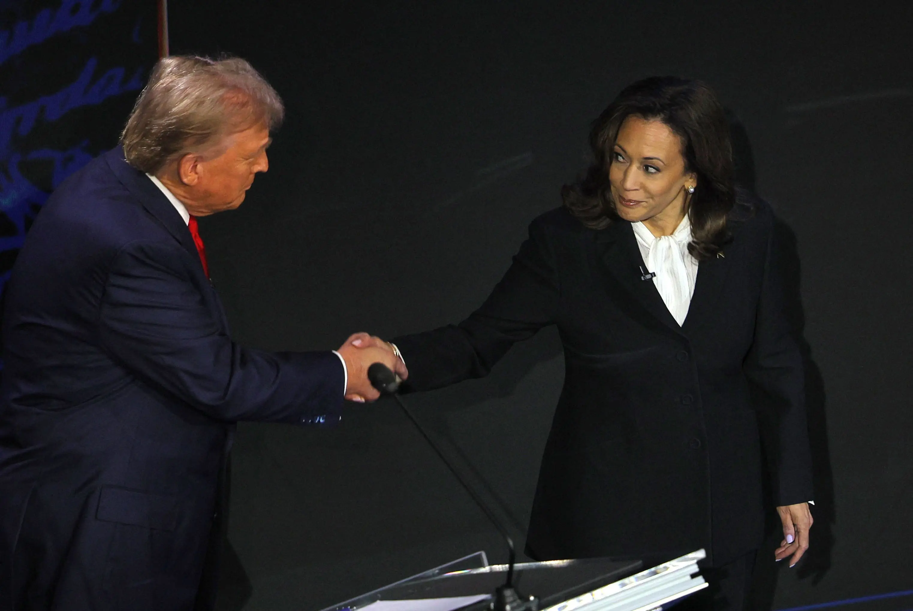 A democrata Kamala Harris e o republicano Donald Trump se cumprimentam durante o debate