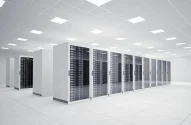 Data center moderno e bem organizado, com fileiras de racks de servidores sob iluminação intensa e espaço otimizado para alta tecnologia e eficiência. Data centers