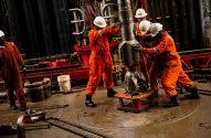 Imagem de técnicos da TotalEnergies trabalhando com maquinário de produção de petróleo
