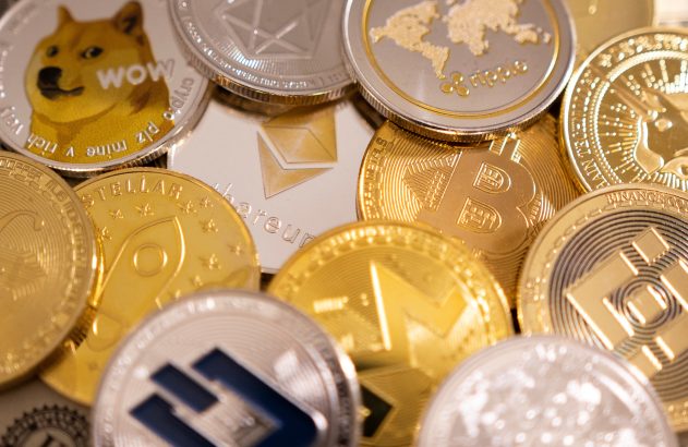 Diversas moedas físicas de criptomoeda, incluindo Dogecoin e Binance Coin, espalhadas.