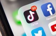 Tela de smartphone exibindo vários ícones de apps, com TikTok mostrando notificação '99'.