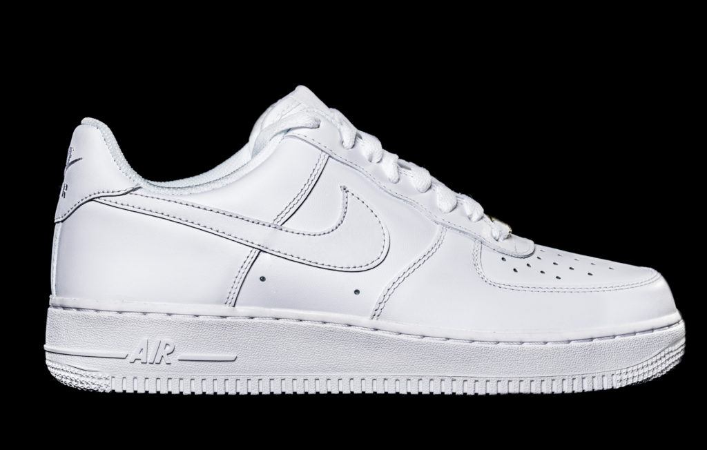 Tênis Nike Air Force 1 branco, vista lateral em fundo preto.