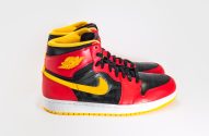 Par de tênis Air Jordan 1 cano alto vermelho, preto e amarelo.