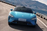 Carro da marca chinesa Xiaomi SU7 frente, azul, em uma estrada, fotografado de frente