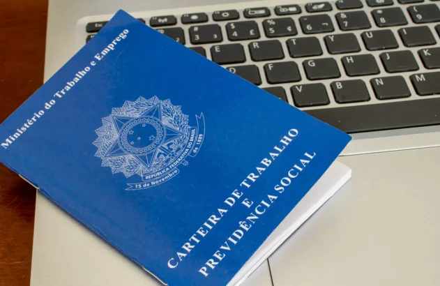 carteira de trabalho em cima de um notebook aberto