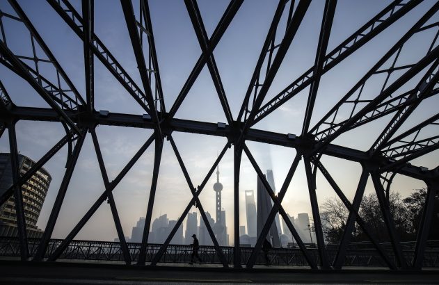 Estrutura metálica treliçada em silhueta emoldura horizonte urbano nebuloso com torre alta e pedestres.