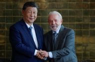 Presidente chinês Xi Jinping e presidente brasileiro Lula da Silva apertam as mãos e sorriem em pose formal.