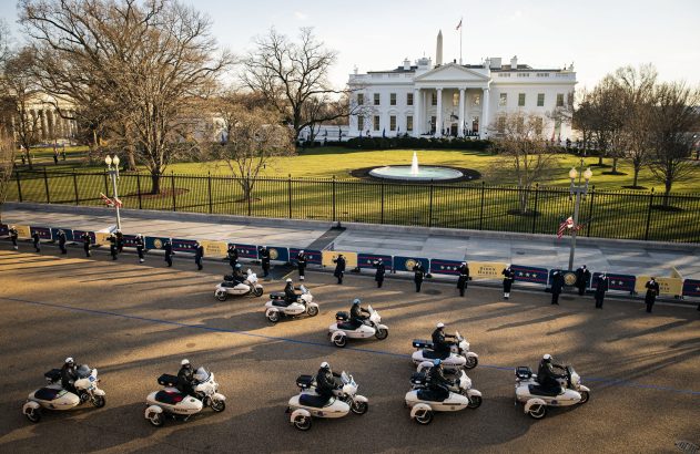 Policiais em triciclos motorizados e a pé em formação diante da Casa Branca.