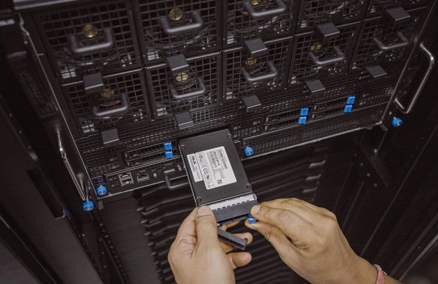 Mãos inserindo um drive em um servidor de rack. Manutenção de hardware de TI.