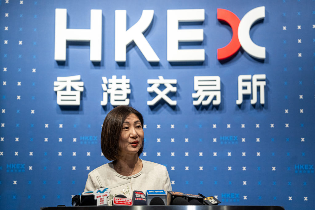 Mulher asiática fala em coletiva de imprensa no HKEX.