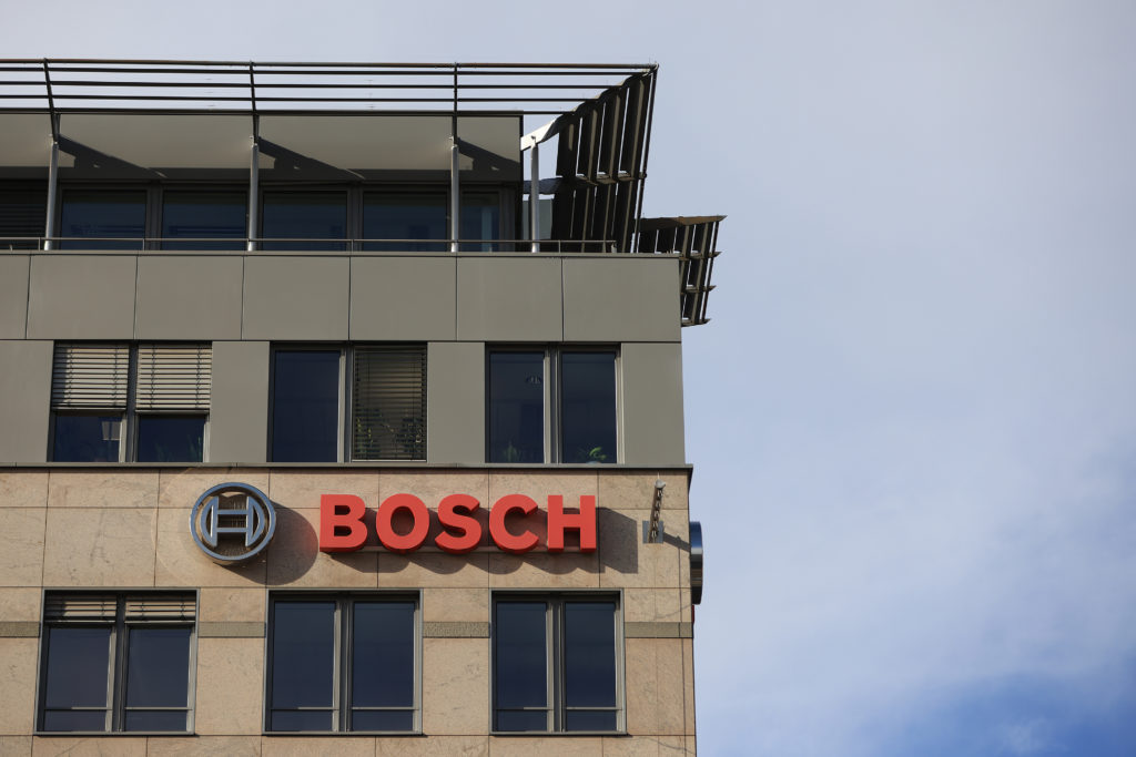 Edifício com o logo e o nome BOSCH em letras vermelhas na fachada. Céu claro ao fundo.