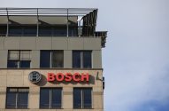 Edifício com o logo e o nome BOSCH em letras vermelhas na fachada. Céu claro ao fundo.