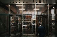 Homem de terno entra na entrada de vidro da Morgan Stanley, 1585 Broadway.